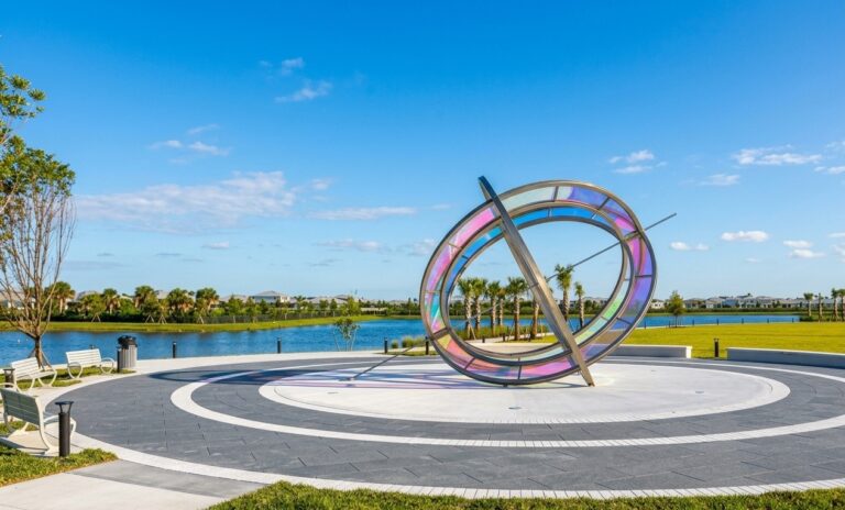 Decorative public park plaza featuring custom circular paver layouts and a concrete pedestal supporting the monumental Stars & Stripes Park sundial sculpture, built by Cobra Construction.